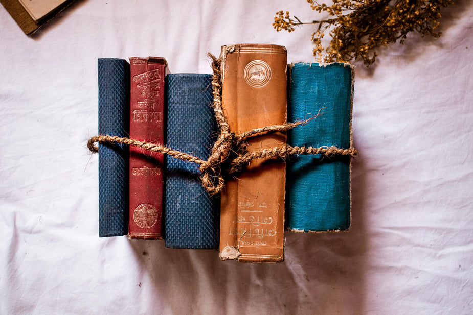 leather bound books wrapped in string overlay