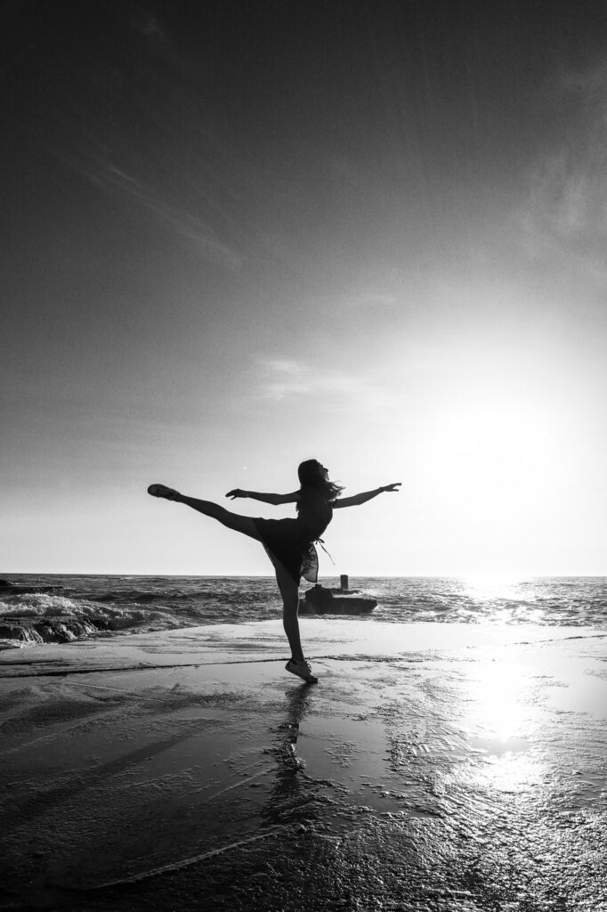 woman in ballerina pose at beach better her health