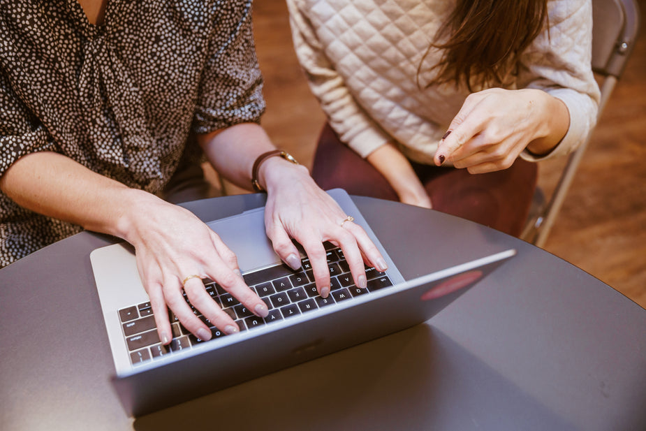 Two students work together at a laptop computer. They are at a Canada Learning Code workshop taking in all they have to offer about successful code and developing