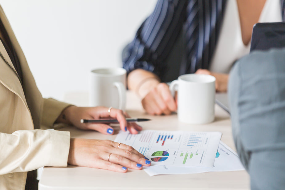 Charts and graphs analyzed at a meeting. People working together in the office to learn how to make their business successful