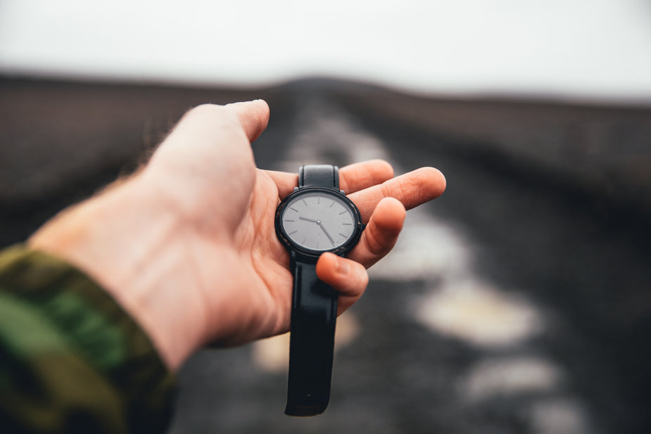 Man tries to tell time over a bumpy, black roads. schedule time to stay healthy while working from home