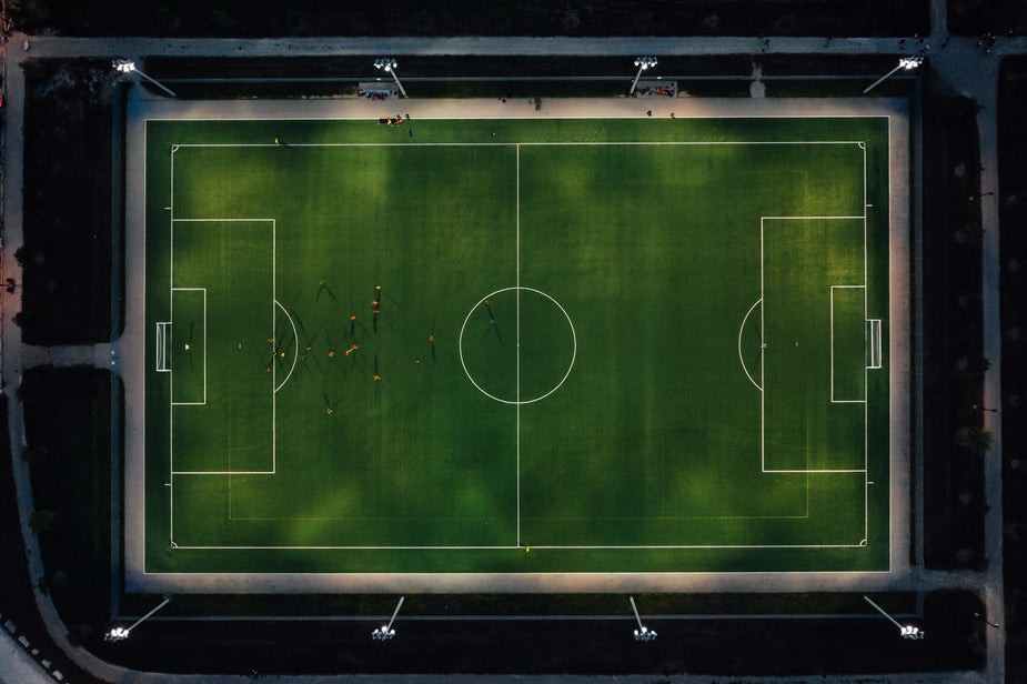 A soccer pitch is lit up at night, allowing the players to practice despite the late hour. Metaphor for long term practice to increase your typing speed