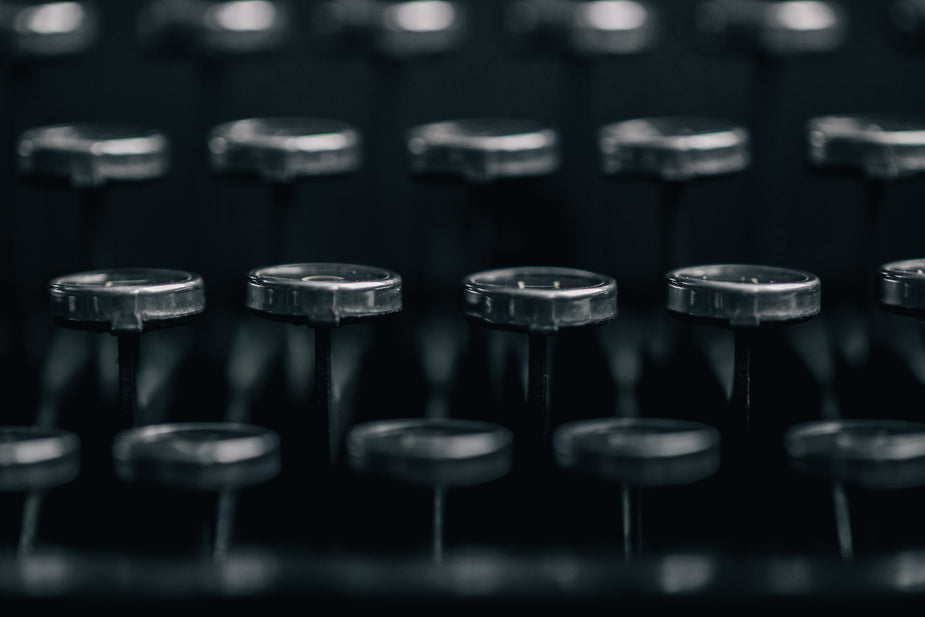 The shiny silvery edges of round typewriter key tops as seen from the side. Rows and rows of letters to help increase your typing speed