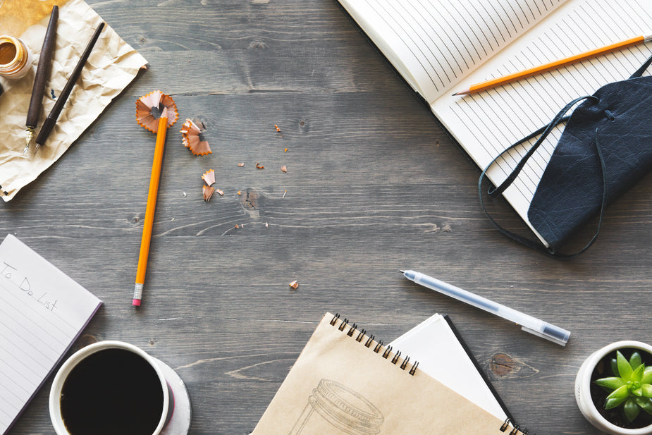 Coffee, pencils, pens and paper in a creative flatlay.