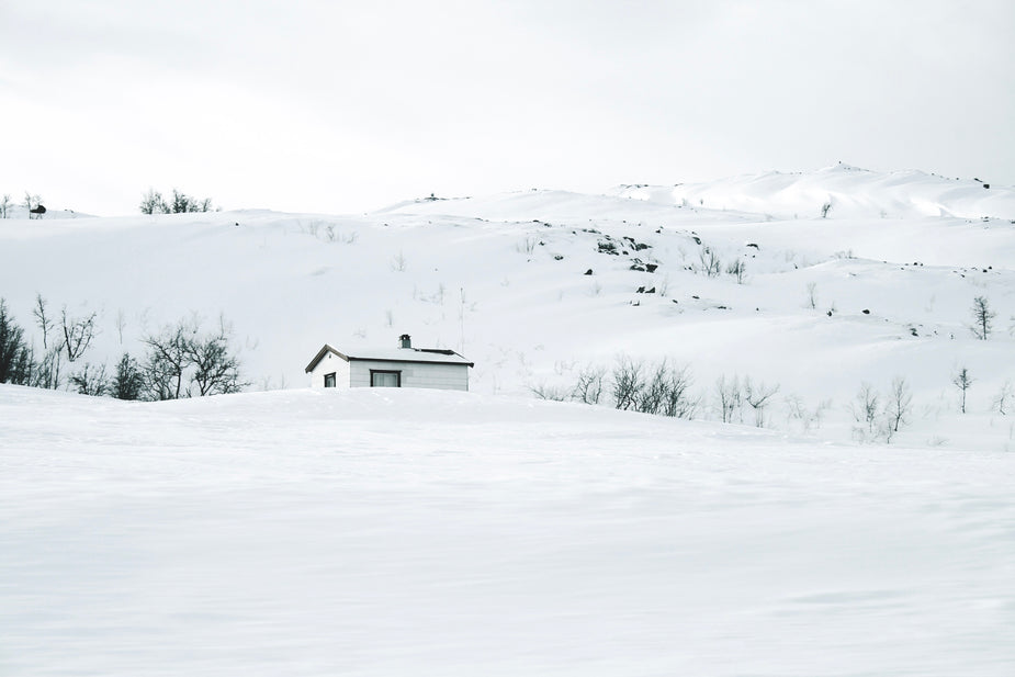 A white wood hut is camouflaged in a snowy, hilly landscape, like James Bond's secret getaway. metaphor for ethics in scopistry and the code of conduct