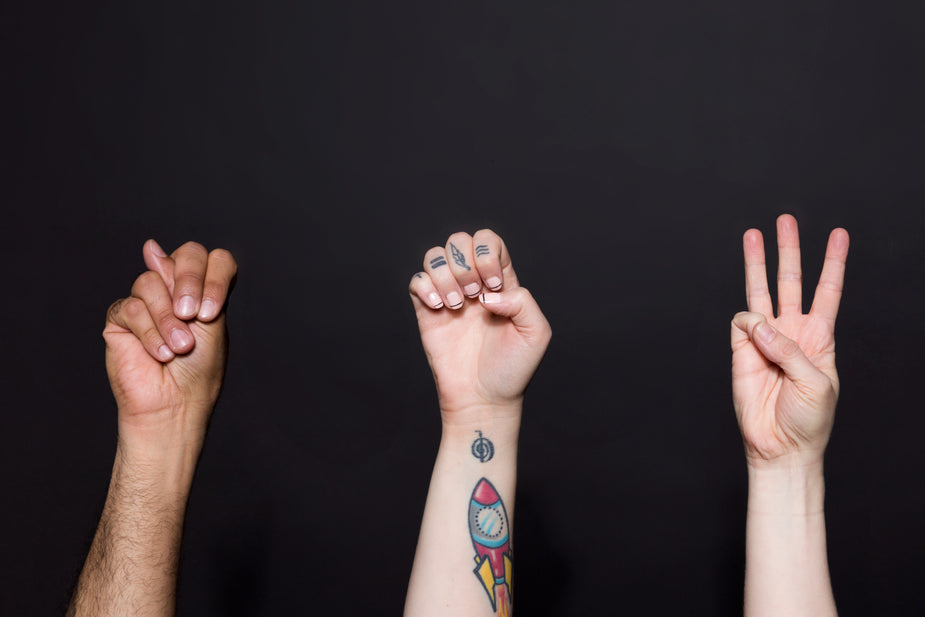 Three hands spell out the word "new" in sign language. metaphor for hand gestures to stop cross talk