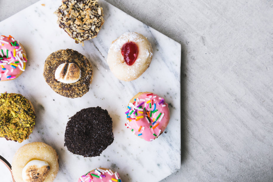 A variety of choice gourmet donuts resting upon a marble hexagon. metaphor for court reporter preferences and good relationships