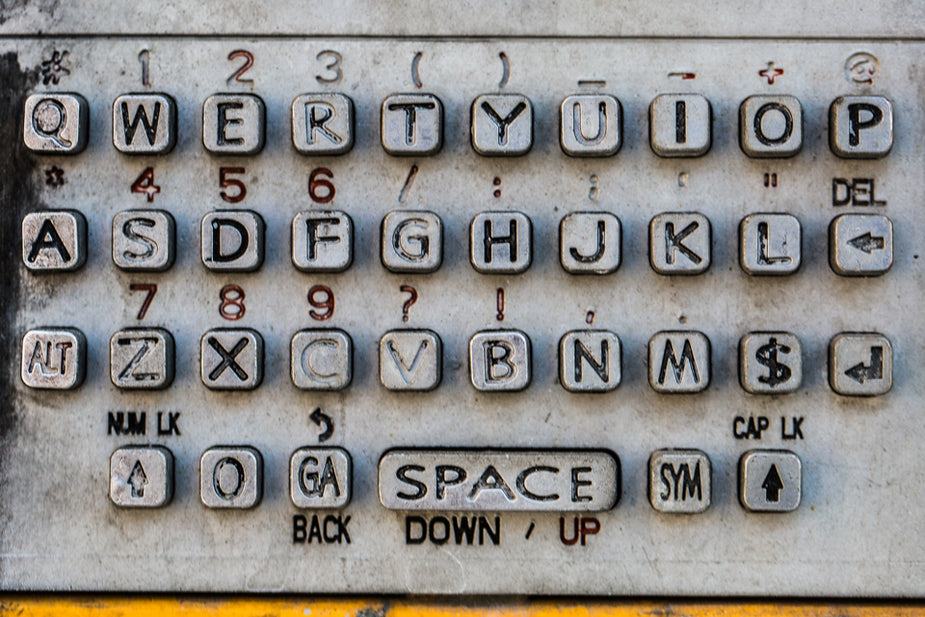 Dirty and used numbers of a silver payphone keypad. You can still find these phones around once in a while but they are aging and often a bit grungy. Scoofer metaphor